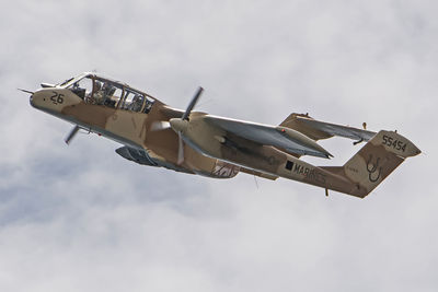 Low angle view of military airplane flying cloudy sky