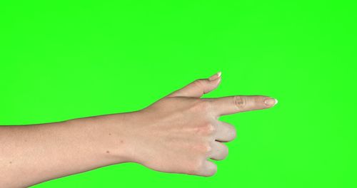 Close-up of human hand against green background