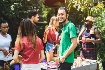 Portrait of happy man with friends enjoying in garden during party