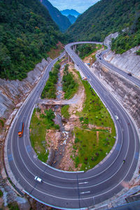 High angle view of vehicles on road by mountain against sky