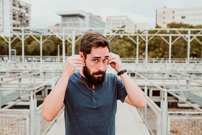 Portrait of young man standing against bridge