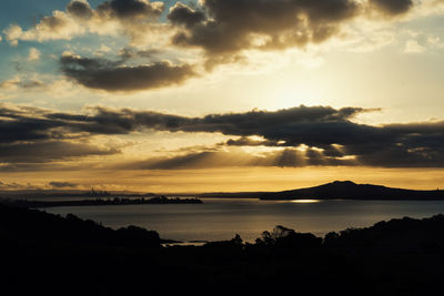 Scenic view of sea against dramatic sky during sunset