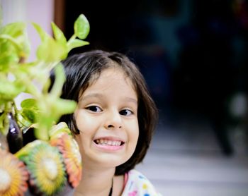 Portrait of smiling girl by plants