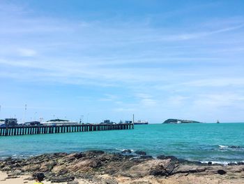 Pier over sea against blue sky