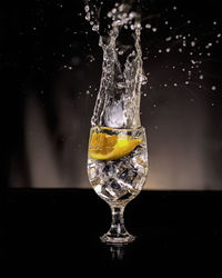 Close-up of water splashing in glass against black background