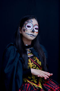 Young woman looking away against black background