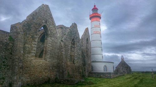 Low angle view of tower against cloudy sky