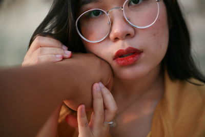 Close-up portrait of woman with hands