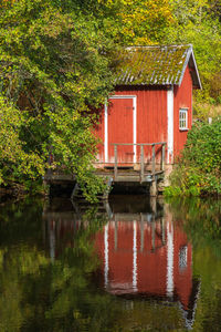 House by lake against trees