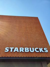 Low angle view of sign against blue sky