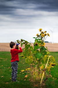 Rear view of boy standing in field