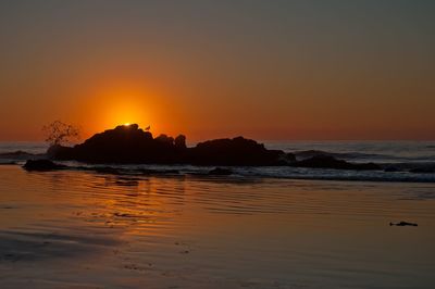 Scenic view of sea against orange sky