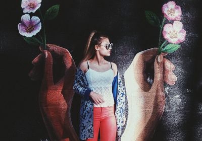 Woman standing by flowering plants