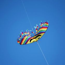 Low angle view of kite flying against clear blue sky