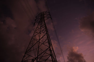 Low angle view of silhouette electricity pylon against sky