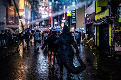 People on wet street at night