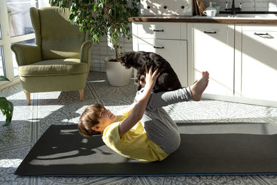 Little boy practicing yoga, stretching, fitness at home. distant online education training at home.