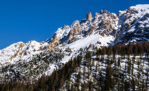 Scenic view of snowcapped mountains against clear blue sky