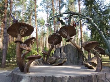 Statue in park against trees in forest