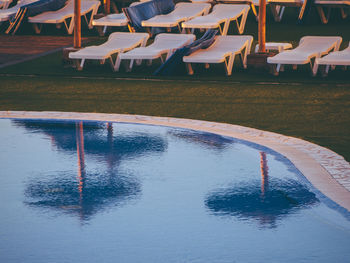Reflection of chairs on swimming pool