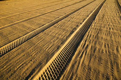 High angle view of tire tracks on field