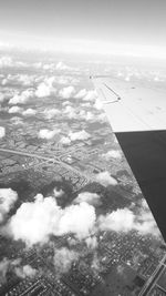 Aerial view of airplane wing over clouds