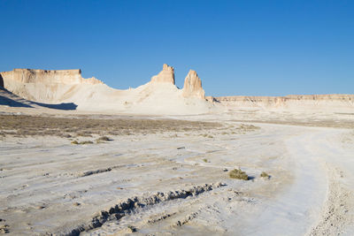 Scenic view of desert against clear blue sky