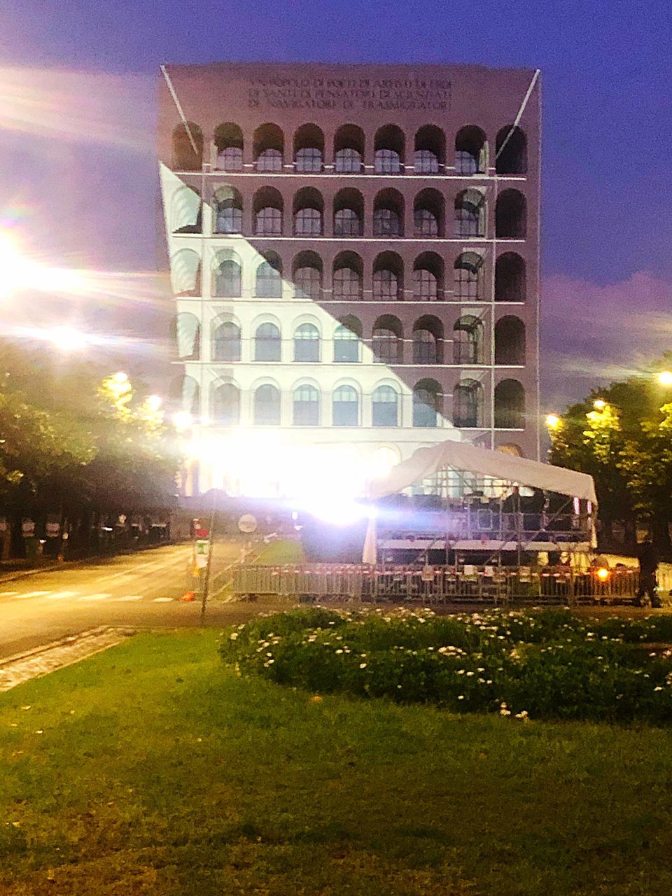 ILLUMINATED BUILDING BY STREET AT NIGHT