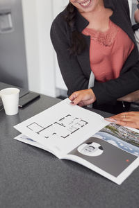 Female estate agent showing house brochure