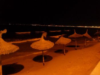 Illuminated lanterns hanging against sky at night