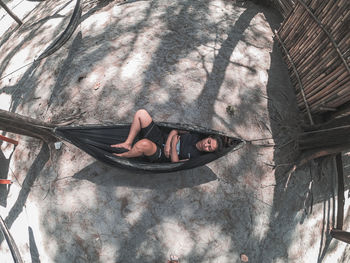 High angle view of woman lying down on hammock