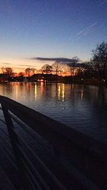 Reflection of trees in water at sunset