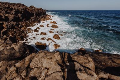 Scenic view of rocks in sea against sky