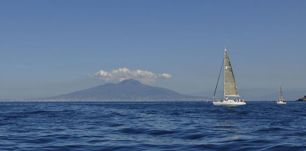 Sailboat sailing on sea against blue sky