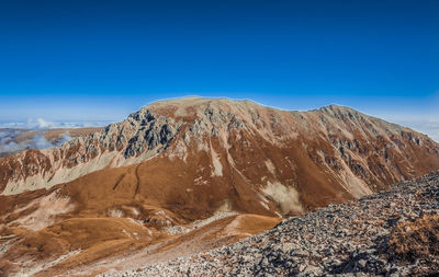 Scenic view of snowcapped mountains against clear blue sky