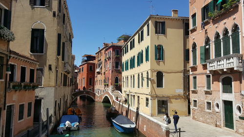 Canal amidst buildings against sky