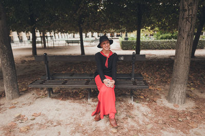 Full length of woman standing on tree trunk