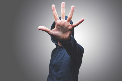 Midsection of person with arms raised against wall