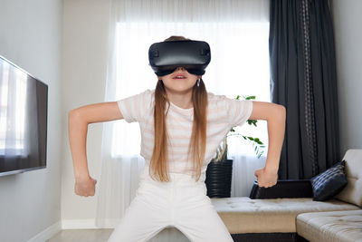 Girl wearing virtual reality simulator at home