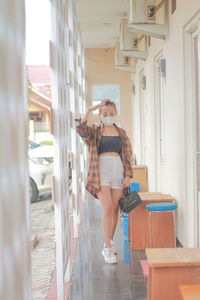 Full length of young woman standing at home