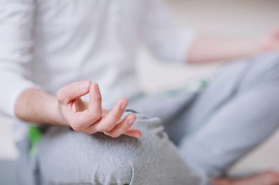 Low section of man doing yoga in studio