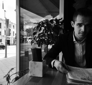 Man sitting with menu at table in restaurant