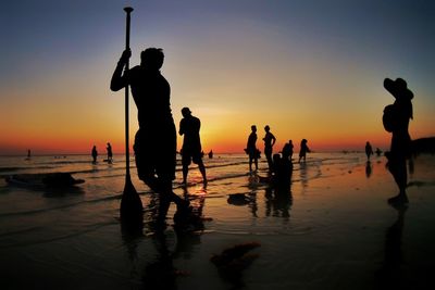 Silhouette people at beach during sunset