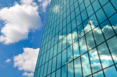 Low angle view of glass building against sky