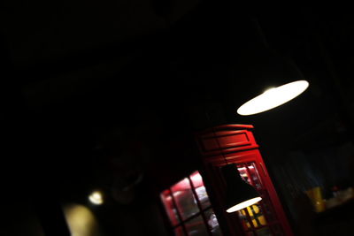 Low angle view of illuminated light bulb against black background