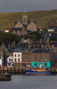 Houses by sea against sky in city