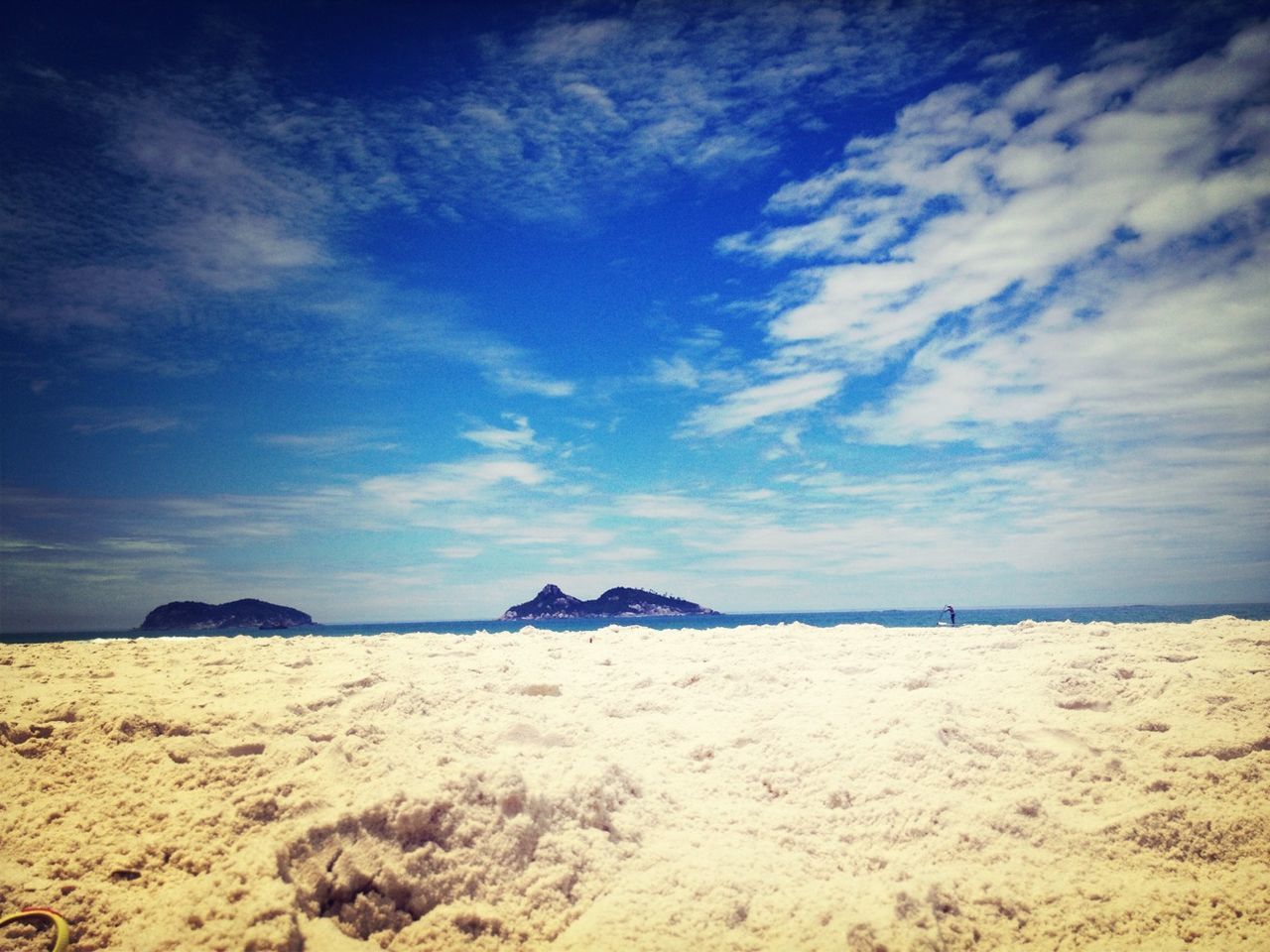 beach, sky, tranquil scene, tranquility, sand, scenics, sea, beauty in nature, shore, nature, cloud - sky, water, blue, cloud, idyllic, remote, non-urban scene, rock - object, horizon over water, cloudy