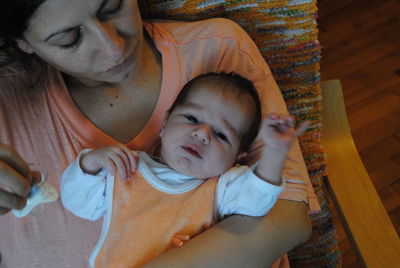 High angle view of mother sitting with toddler son on chair