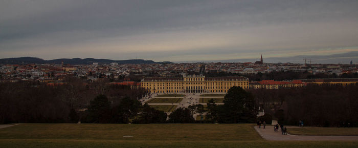 Buildings in town against cloudy sky