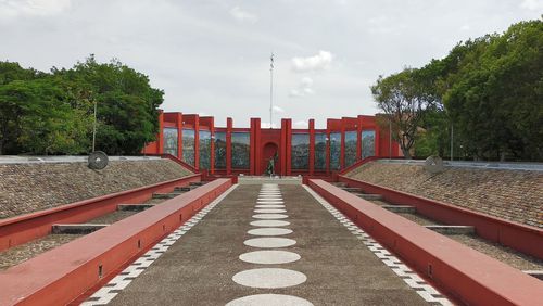 Footpath amidst buildings against sky